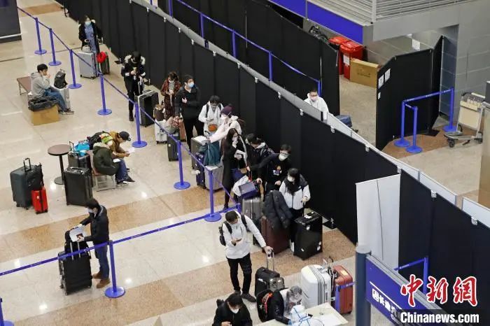 入境人员在浦东机场T1航站楼内等待相关信息核查。 殷立勤 摄